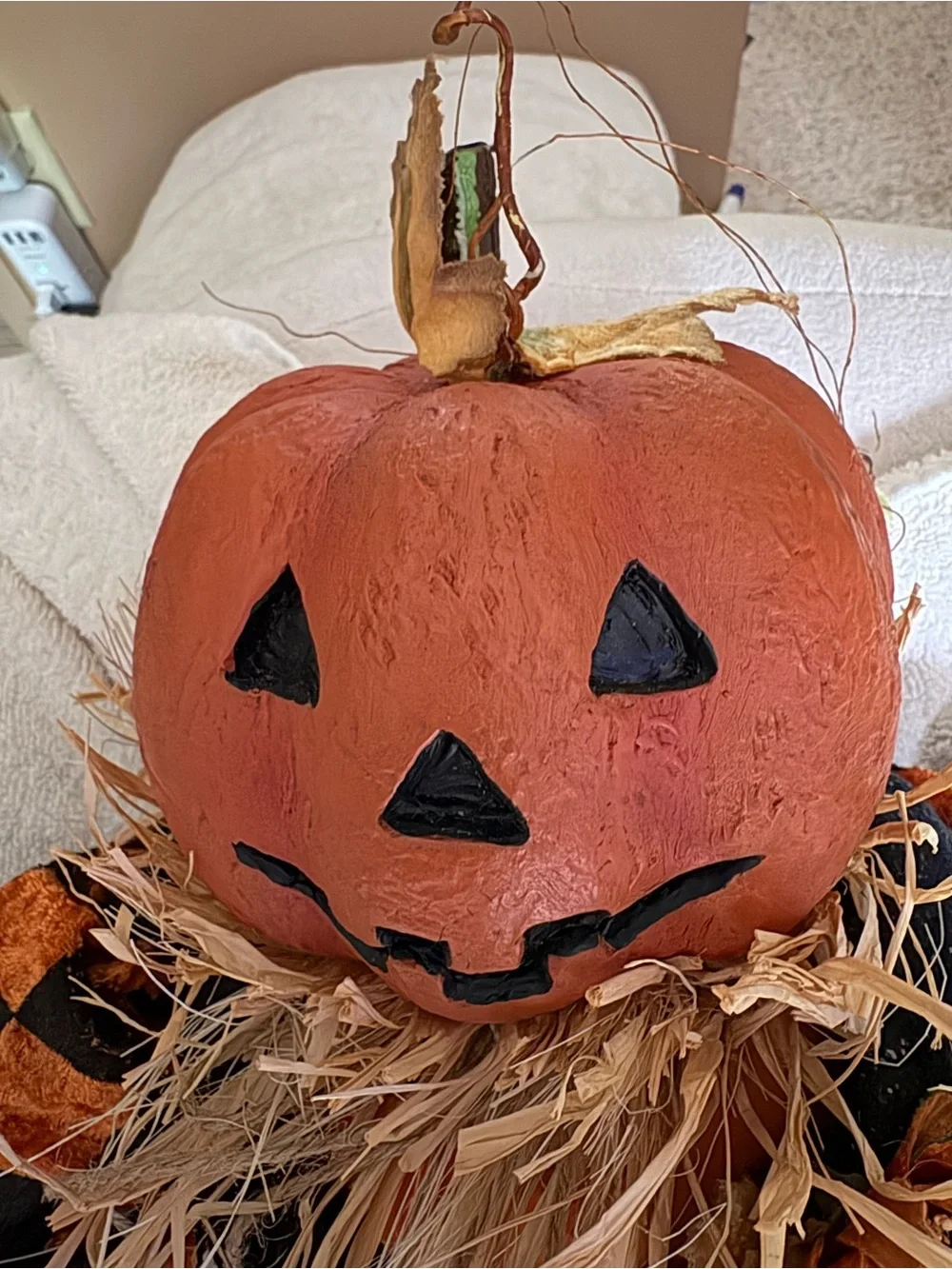 Cute resin head pumpkin doll with checkered jackets, cords, & straw accents.